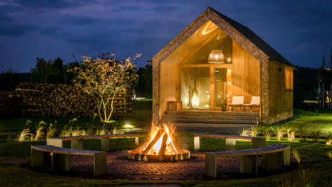 abendliche Außenansicht Sauna Seezeit Lodge Saunadorf mit Feuerstelle
