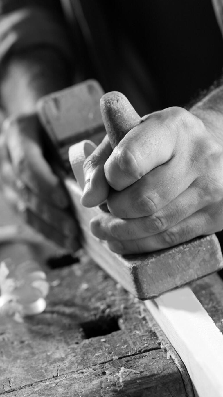 Nahaufnahme Tischler beim Hobeln von Holz 9-16